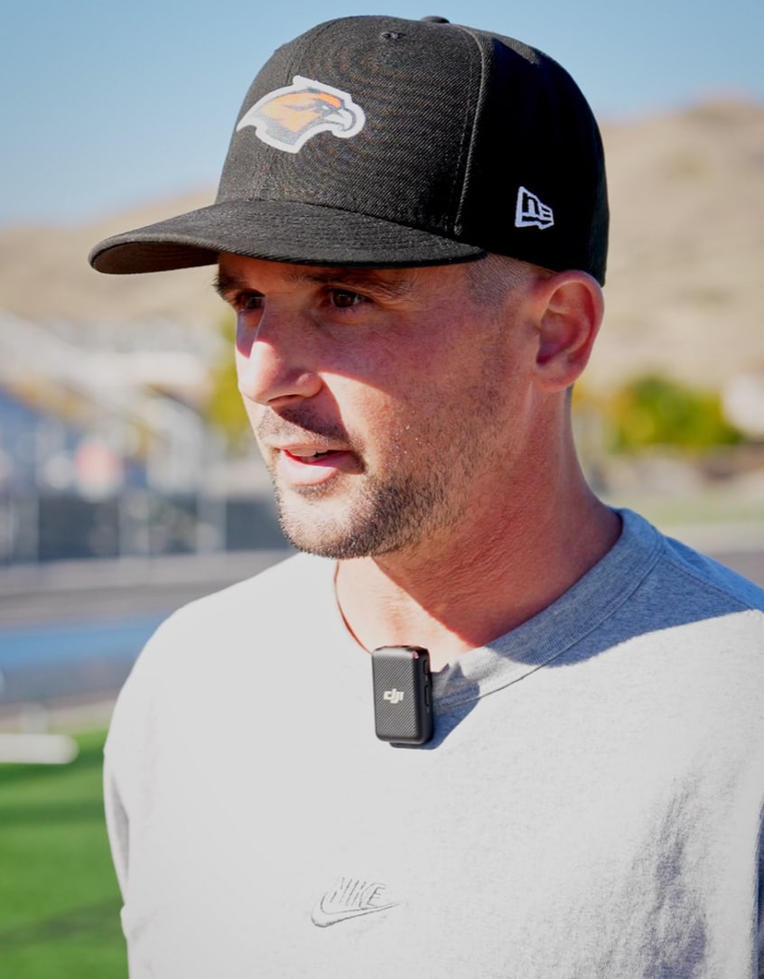 Coach Hemm speaking at a football field
